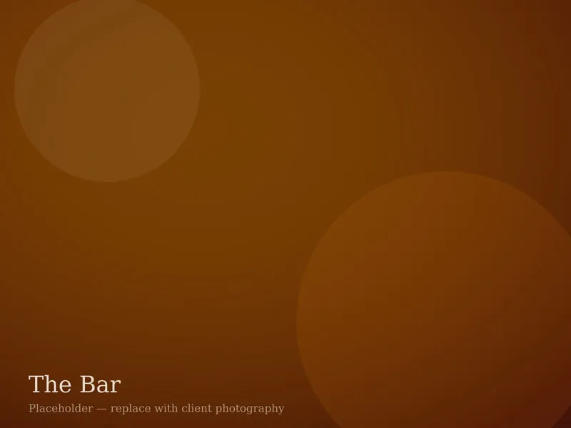 The bar at The Juniper Table with a back wall of Colorado gins and low amber lighting